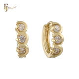 Pendientes huggie de tres piedras en oro rosa de 14 quilates.