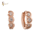 Pendientes huggie de tres piedras en oro rosa de 14 quilates.